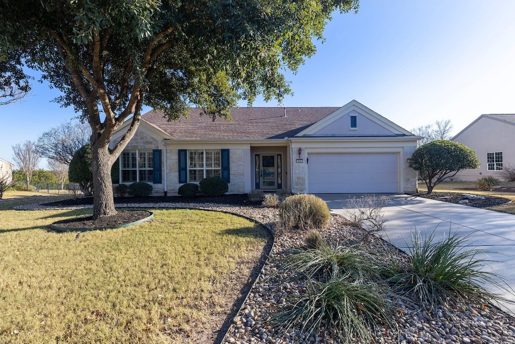 ranch-style house featuring a front yard and a garage