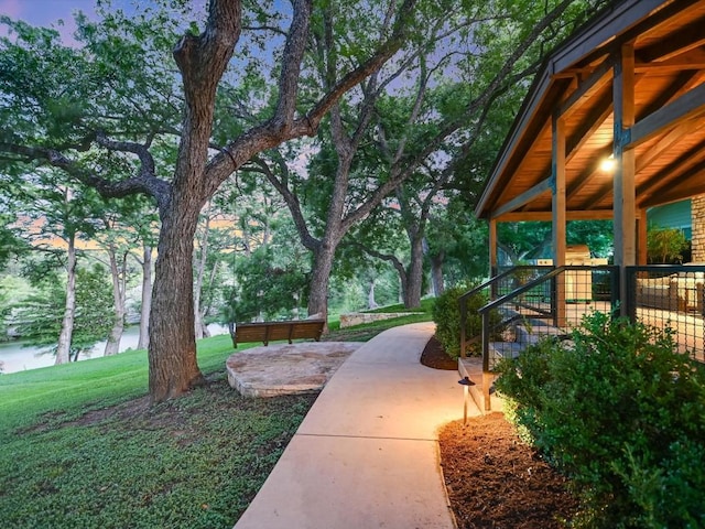 yard at dusk with a patio area and a water view