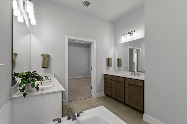 6304 Rotunda Vw, Austin, TX 78747 - bathroom featuring two vanities, tile patterned flooring, and a tub to relax in