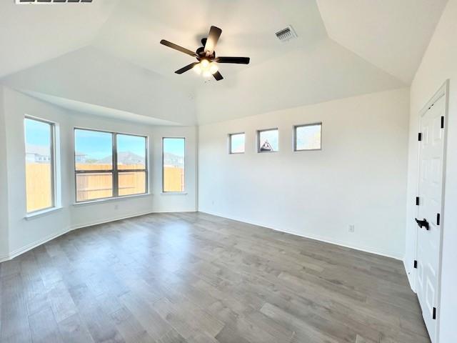 empty room featuring hardwood / wood-style floors, vaulted ceiling, and ceiling fan