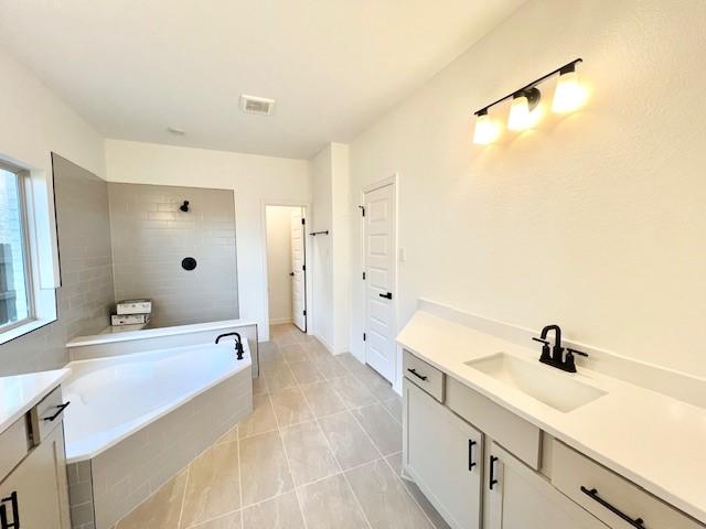 bathroom with tile patterned floors, vanity, and separate shower and tub