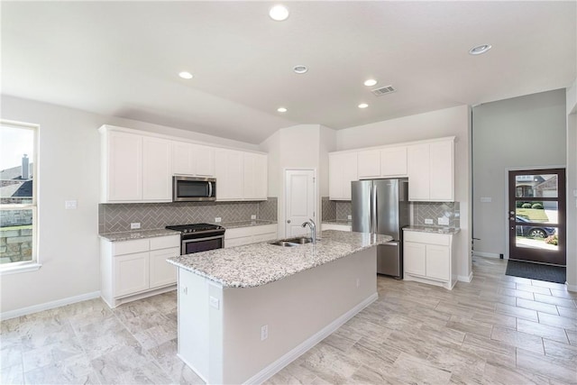 kitchen featuring a center island with sink, sink, white cabinets, and stainless steel appliances