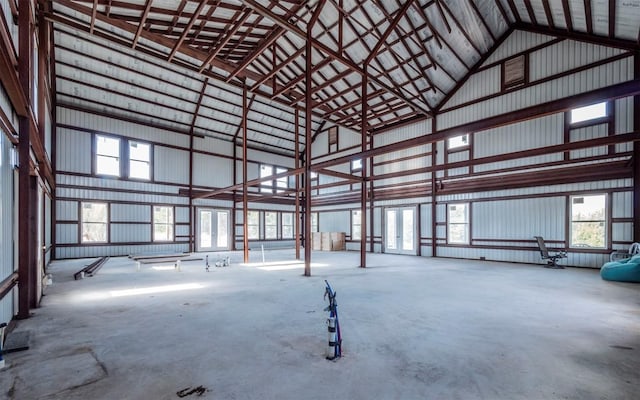 interior space with high vaulted ceiling and concrete floors