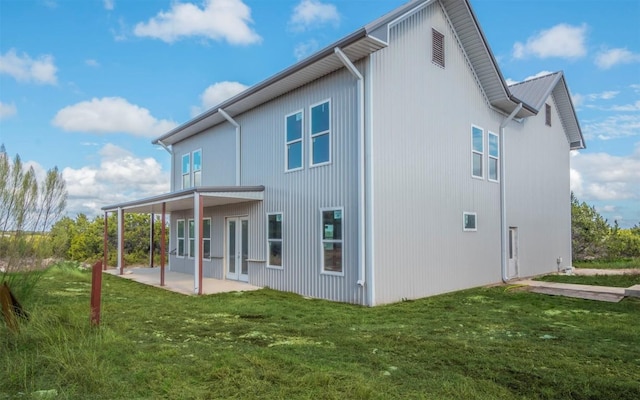 back of property with a patio area and a yard