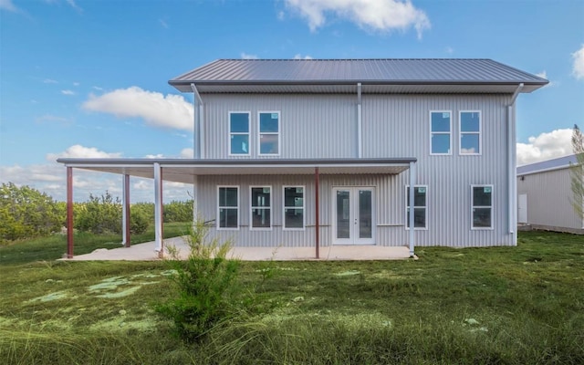 back of property with a yard and french doors