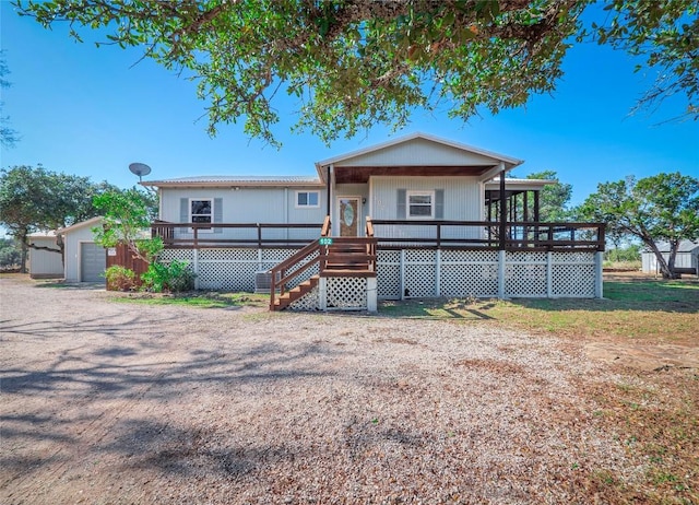 view of front of house featuring an outdoor structure, a deck, and a garage