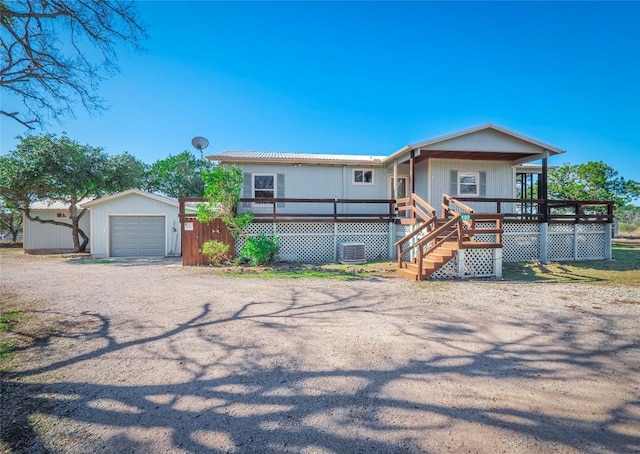 view of front of home with a garage, an outdoor structure, and a deck