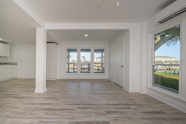 246 Starboard Ave, Rockport, TX 78382 - unfurnished living room featuring a wall mounted air conditioner, baseboards, light wood finished floors, ceiling fan, and recessed lighting
