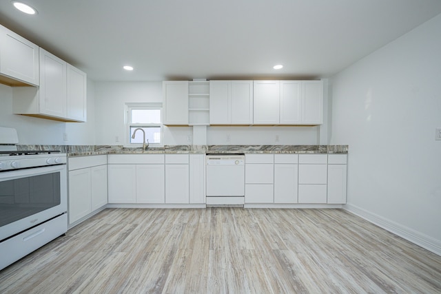 246 Starboard Ave, Rockport, TX 78382 - kitchen featuring white appliances, light wood-type flooring, white cabinets, light stone countertops, and baseboards