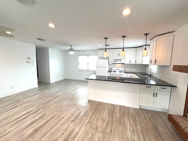 246 Starboard Ave, Rockport, TX 78382 - kitchen with white appliances, a sink, a peninsula, dark countertops, and open floor plan