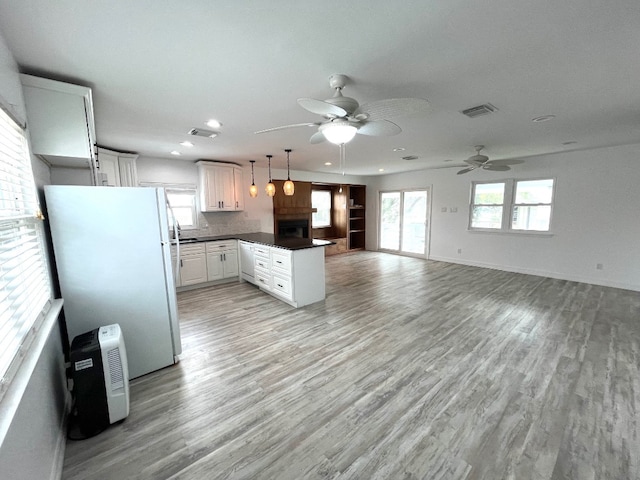 246 Starboard Ave, Rockport, TX 78382 - kitchen featuring white appliances, a peninsula, ceiling fan, dark countertops, and light wood-style floors