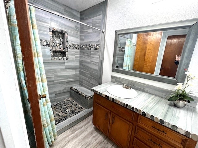 246 Starboard Ave, Rockport, TX 78382 - full bath featuring tiled shower, vanity, and wood finished floors