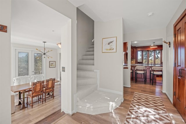 staircase with an inviting chandelier and hardwood / wood-style flooring