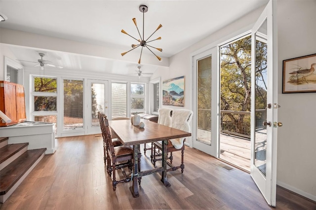 dining room featuring hardwood / wood-style floors, ceiling fan with notable chandelier, and french doors