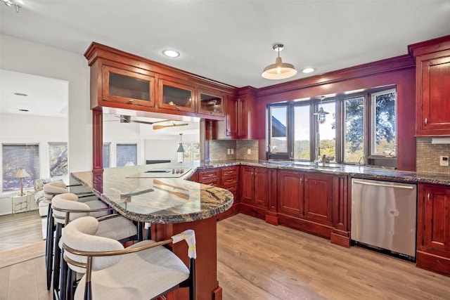 kitchen with dishwasher, a kitchen breakfast bar, backsplash, and kitchen peninsula