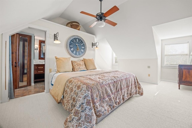 carpeted bedroom with ensuite bathroom, ceiling fan, and lofted ceiling