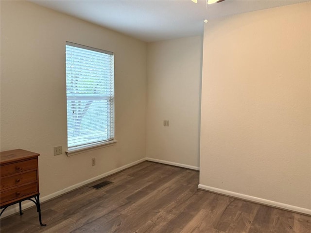 unfurnished room featuring a wealth of natural light and dark wood-type flooring