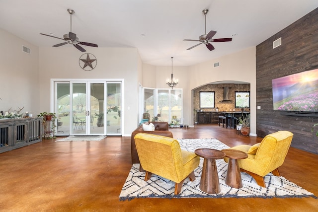 living room with ceiling fan with notable chandelier and a towering ceiling