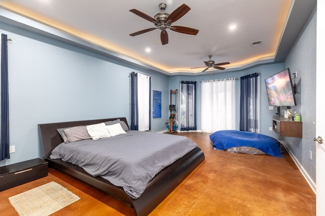 bedroom with a raised ceiling and ceiling fan