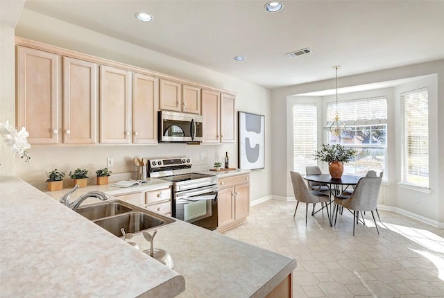 kitchen with pendant lighting, stainless steel appliances, light brown cabinetry, and sink