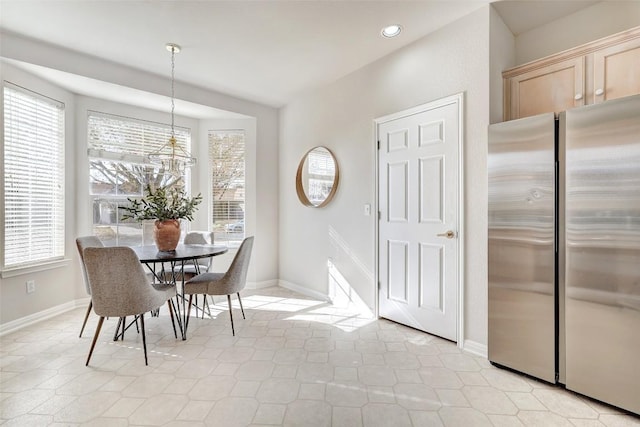 dining area featuring a notable chandelier, a healthy amount of sunlight, and light tile patterned floors