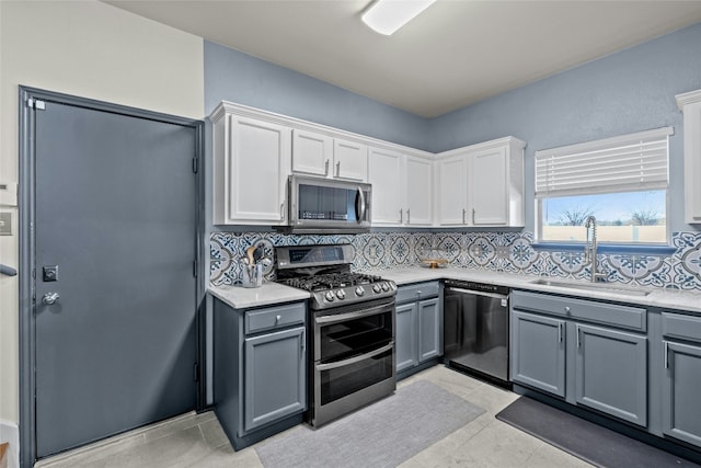 kitchen featuring gray cabinetry, sink, tasteful backsplash, white cabinets, and appliances with stainless steel finishes