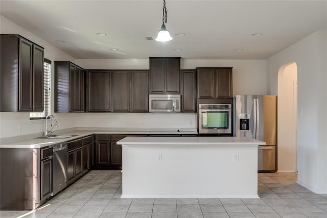 kitchen featuring pendant lighting, a center island, sink, appliances with stainless steel finishes, and dark brown cabinetry