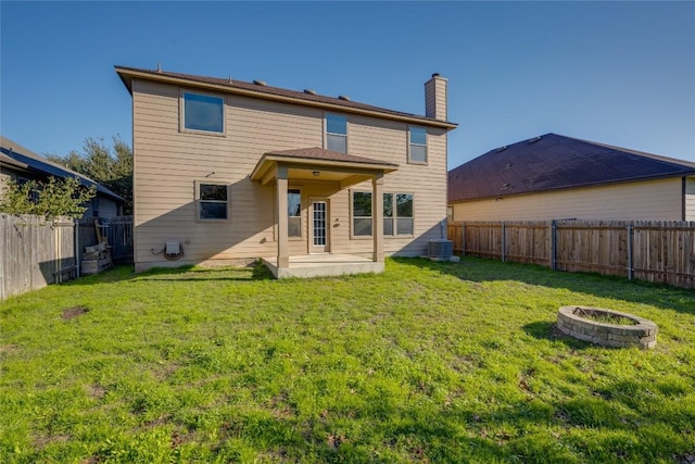 back of house featuring a patio area, a yard, and an outdoor fire pit