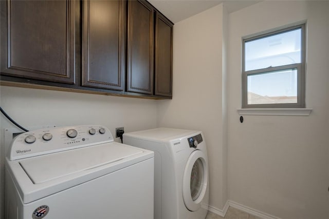 clothes washing area with washing machine and dryer and cabinets