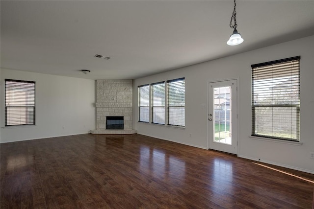 unfurnished living room featuring a fireplace and dark wood-type flooring