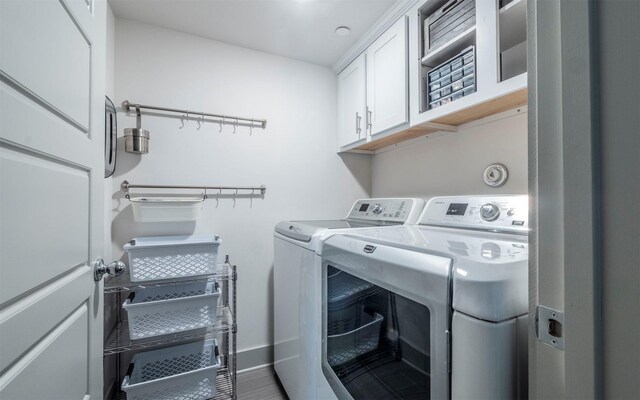 washroom featuring washer and dryer and cabinets