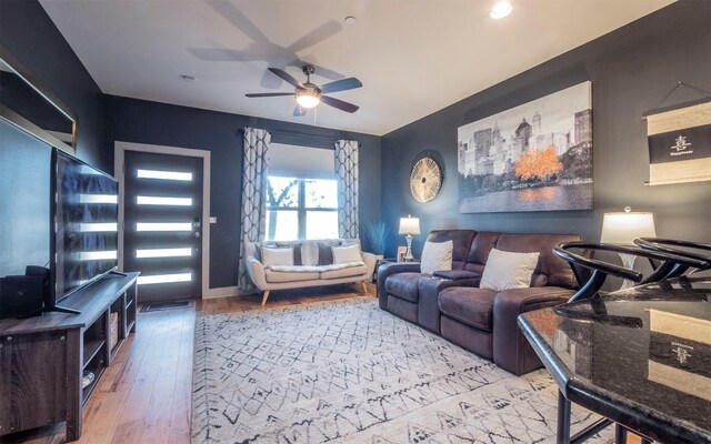 living room with light hardwood / wood-style floors and ceiling fan