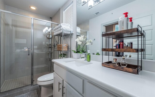 bathroom featuring vanity, toilet, and walk in shower