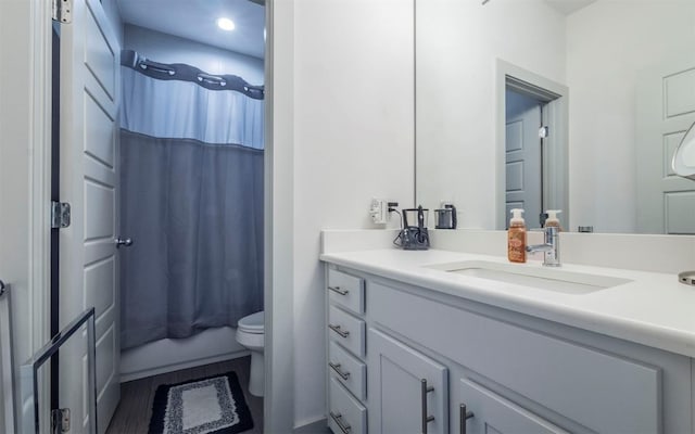 full bathroom with vanity, toilet, wood-type flooring, and shower / tub combo with curtain