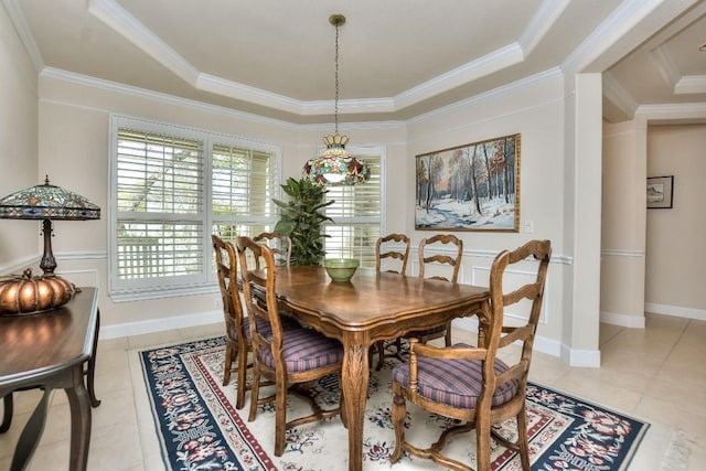 dining space with a raised ceiling, light tile patterned floors, and ornamental molding