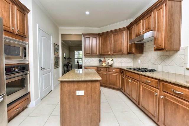 kitchen featuring light tile patterned flooring, light stone countertops, ornamental molding, a kitchen island, and stainless steel appliances