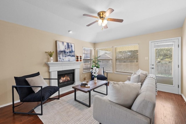 living room with hardwood / wood-style flooring, ceiling fan, and a tray ceiling