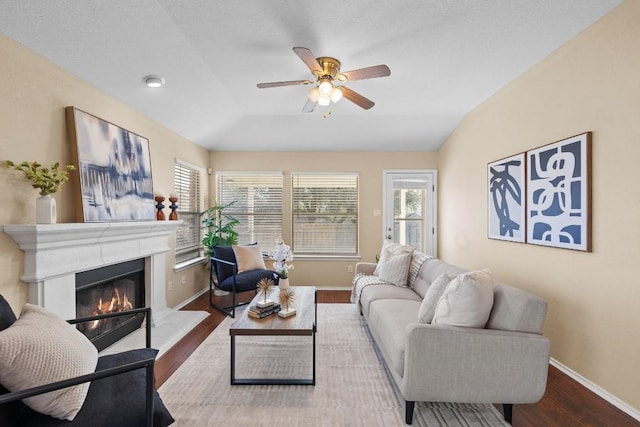 living room featuring ceiling fan, hardwood / wood-style floors, and lofted ceiling