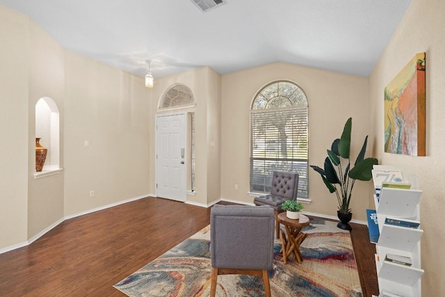 living area with dark hardwood / wood-style floors and vaulted ceiling