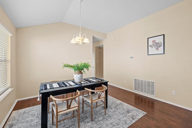 dining area featuring an inviting chandelier, lofted ceiling, and hardwood / wood-style flooring