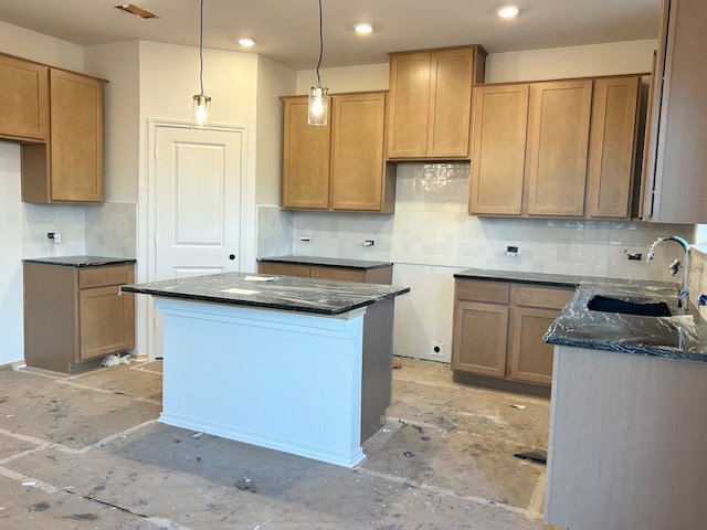 kitchen with tasteful backsplash, dark stone counters, sink, decorative light fixtures, and a kitchen island