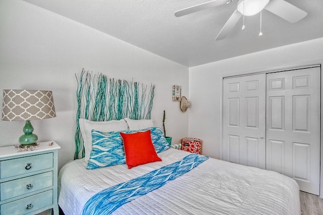 bedroom featuring light hardwood / wood-style flooring, a closet, and ceiling fan