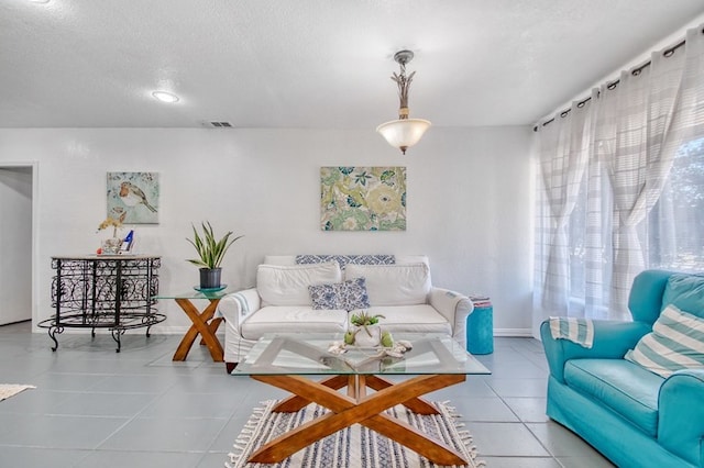 living room featuring a textured ceiling and light tile patterned flooring