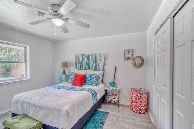 bedroom with light wood-type flooring, a closet, and ceiling fan