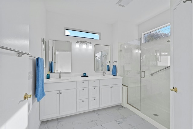 bathroom with a wealth of natural light, a shower with door, and vanity