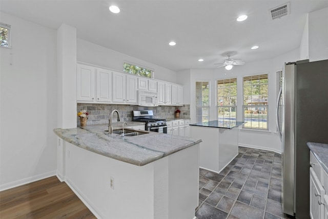 kitchen featuring kitchen peninsula, white cabinetry, sink, and appliances with stainless steel finishes