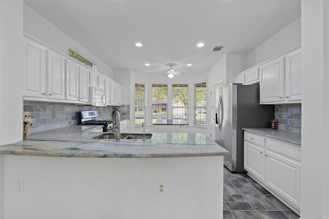 kitchen featuring white cabinets, kitchen peninsula, and stainless steel appliances