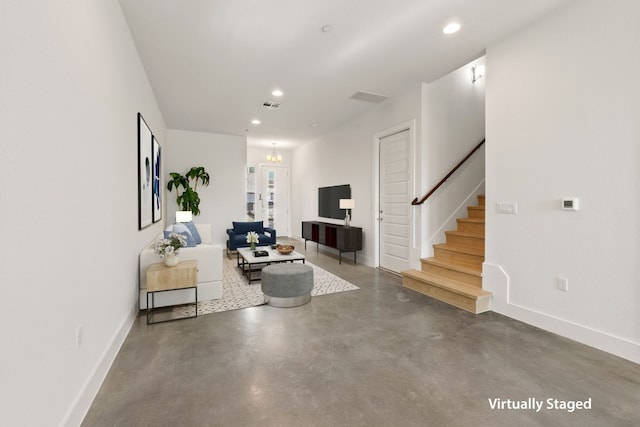 living room featuring a chandelier and concrete floors