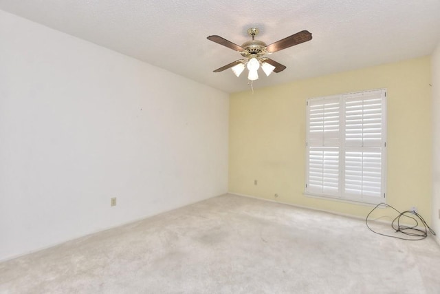 spare room featuring carpet flooring, ceiling fan, and a textured ceiling