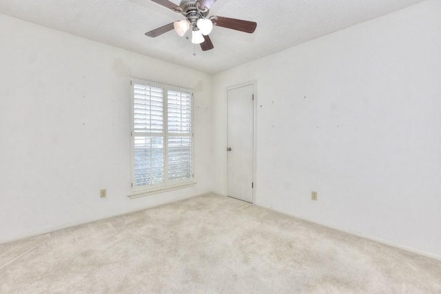 spare room with ceiling fan and light carpet